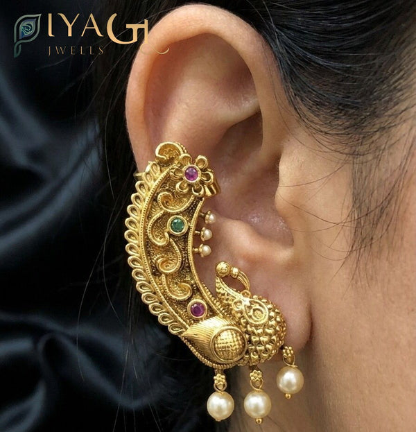 Close up of antique polish brass ear cuff with peacock design and matching necklace set with floral motifs - PiyaGuJwells
