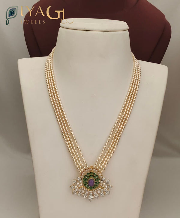 Cream pearl imitation necklace with gold-tone pendant featuring purple center stone and green surrounding stones. - PiyaGuJwells