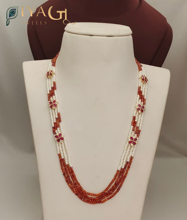 Multi-strand imitation necklace with red and white beads and flower motifs on a display bust - PiyaGuJwells