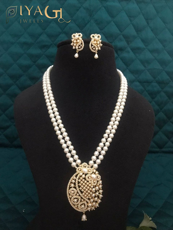 Imitation pearl necklace set with heavy pendant and matching earrings displayed on a bust. - PiyaGuJwells