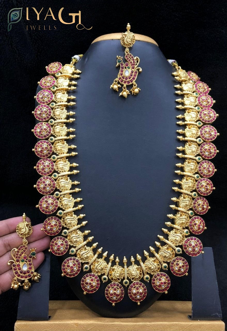 Close up of an antique polish brass metal long haram set with kempu stones, matching earrings and maang tikka displayed on a mannequin. - PiyaGuJwells