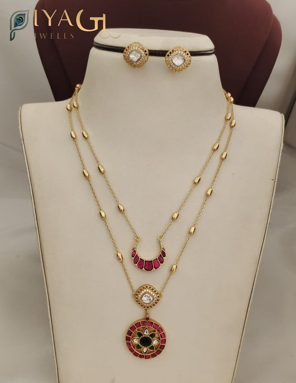 Golden finish Jadau Kundan necklace set with red and black stone pendants on a display bust. - PiyaGuJwells