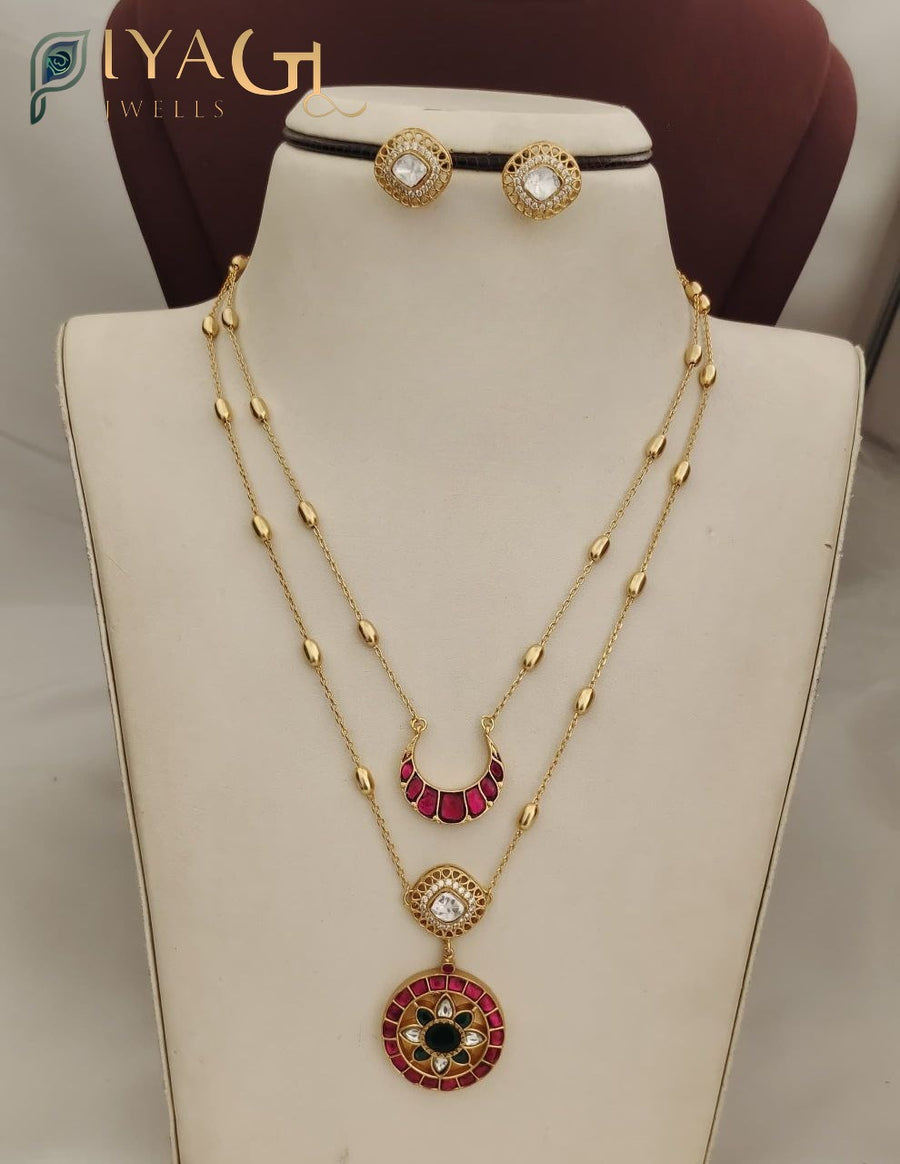 Golden finish Jadau Kundan necklace set with red and black stone pendants on a display bust. - PiyaGuJwells