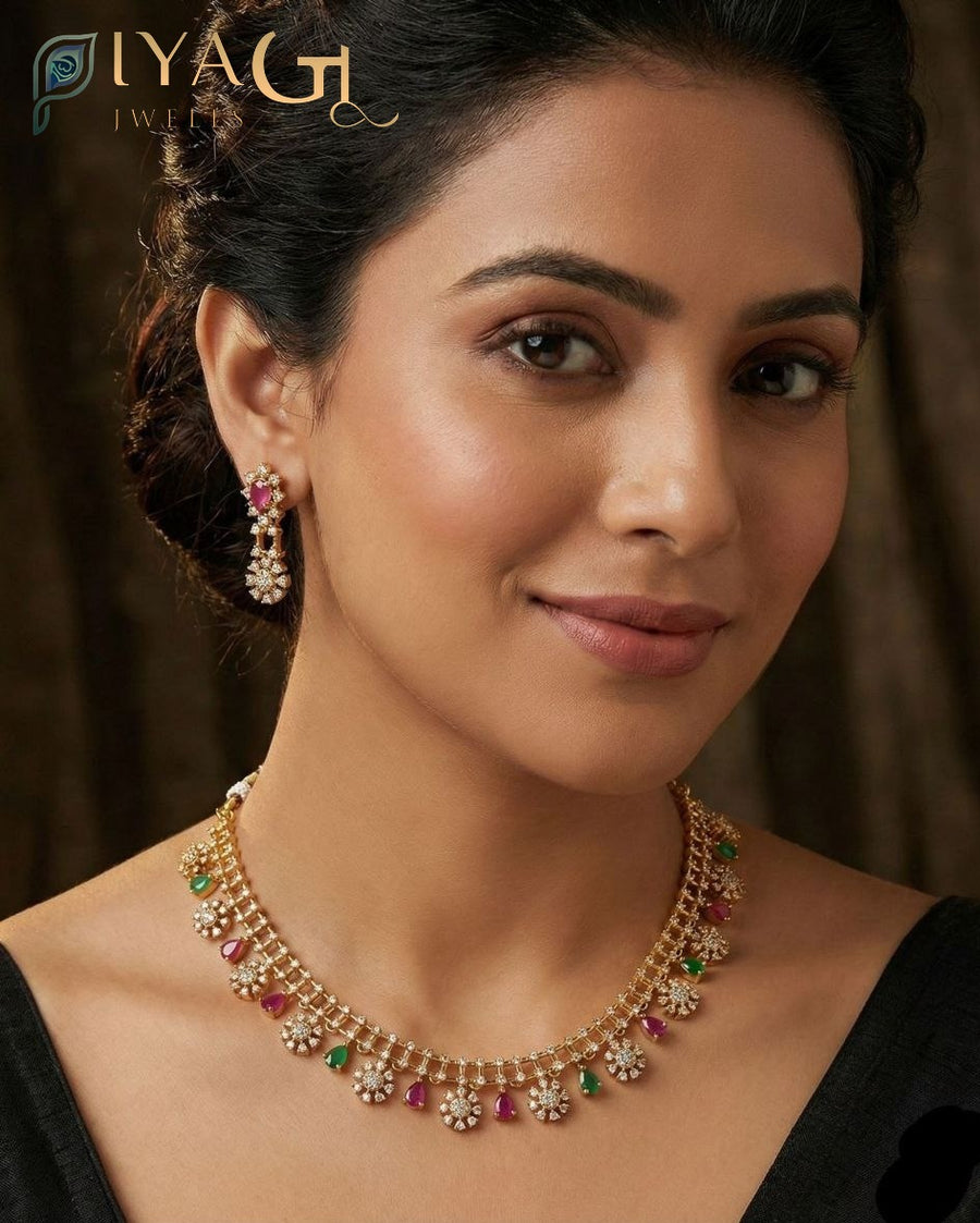 Gold-colored antique finish necklace set with pink and green imitation stones and matching earrings displayed on a bust. - PiyaGuJwells