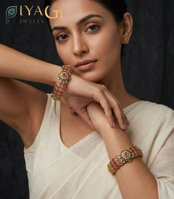 Model wearing antique polish brass metal bangle kadda with red and green AD stones. - PiyaGuJwells