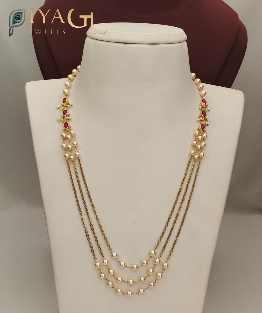A white mannequin displaying a PC's imitation necklace with pearls and red stones in a multi-layer design. - PiyaGuJwells