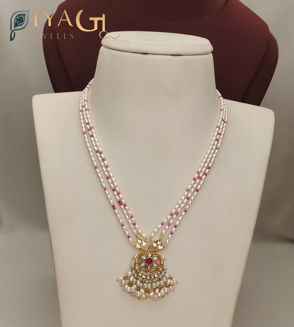 White pearl and pink bead multi-strand necklace with gold-tone floral pendant on a mannequin display. - PiyaGuJwells