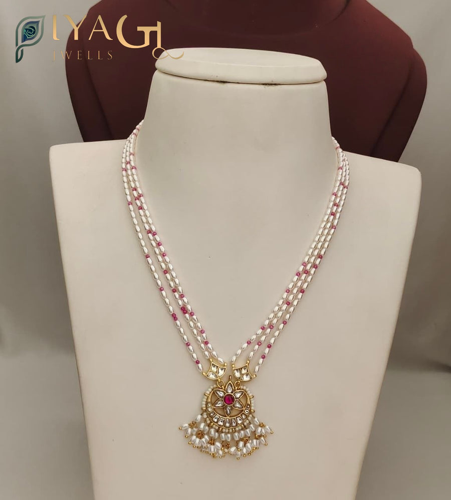 White pearl and pink bead multi-strand necklace with gold-tone floral pendant on a mannequin display. - PiyaGuJwells