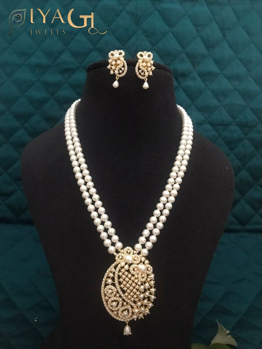 Imitation pearl necklace set with heavy pendant and matching earrings displayed on a bust. - PiyaGuJwells