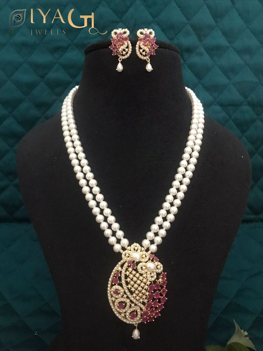 Imitation pearl necklace set with heavy pendant and matching earrings displayed on a bust. - PiyaGuJwells