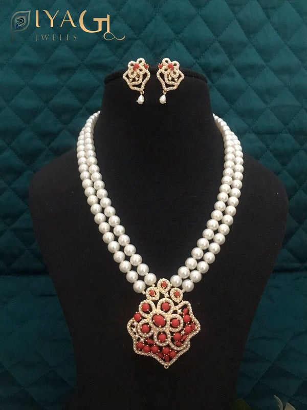 Black mannequin displaying a double strand pearl necklace with a floral pendant and matching earrings. - PiyaGuJwells
