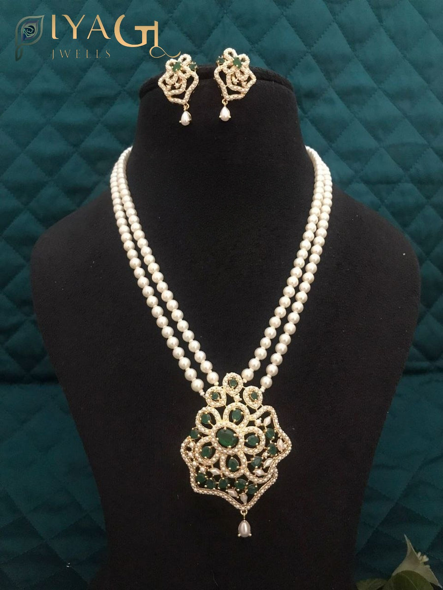 Black mannequin displaying a double strand pearl necklace with a floral pendant and matching earrings. - PiyaGuJwells