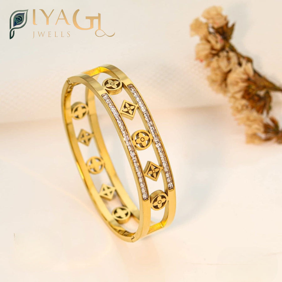 Gold tone stainless steel openable bracelet featuring alternating floral and geometric designs set with small clear stones. - PiyaGuJwells