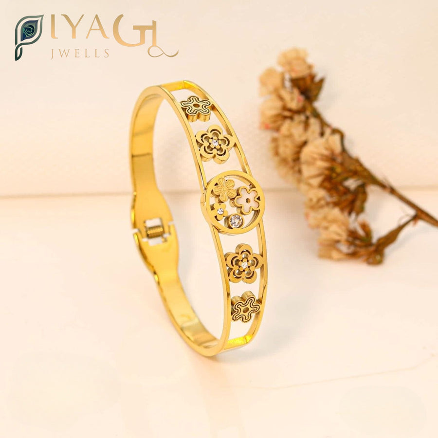 A golden openable bracelet with flower designs and small stones on a white background - PiyaGuJwells